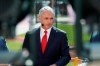 Commissioner Rob Manfred is interviewed as the American League players warm-up for the MLB baseball All-Star Game, Tuesday, July 9, 2019, in Cleveland. (AP Photo/John Minchillo)