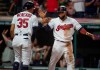 Cleveland Indians' Oscar Mercado, left, celebrates with Carlos Santana after they scored on a thee-run double by Yasiel Puig off Philadelphia Phillies relief pitcher Cole Irvin during the seventh inning of a baseball game in Cleveland, Sunday, Sept. 22, 2019. (AP Photo/Phil Long)