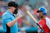Home plate umpire Brian deBrauwere, left, calls a strike given to him by a radar system over an earpiece as Liberty Division's Tyler Ladendorf, right, of the High Point Rockers, strikes out to Freedom Division's Mitch Atkins, of the York Revolution, during the first inning of the Atlantic League All-Star minor league baseball game, Wednesday, July 10, 2019, in York, Pa. deBrauwere wore the earpiece connected to an iPhone in his ball bag which relayed ball and strike calls upon receiving it from a TrackMan computer system that uses Doppler radar. The independent Atlantic League became the first American professional baseball league to let the computer call balls and strikes during the all star game. (AP Photo/Julio Cortez)