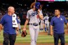 Los Angeles Dodgers relief pitcher Dustin May, middle, walks off the field as he is flanked by medical staff Neil Rampe, left, and Yosuke Nakajima, right, after May was hit by a batted ball from Arizona Diamondbacks' Jake Lamb during the fourth inning of a baseball game Sunday, Sept. 1, 2019, in Phoenix. (AP Photo/Ross D. Franklin)