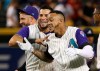 Arizona Diamondbacks' Ketel Marte, right, celebrates his walk-off single against the Atlanta Braves in the 10th inning with David Peralta, middle, and Merrill Kelly, left, in a baseball game Thursday, May 9, 2019, in Phoenix. The Diamondbacks won 3-2. (AP Photo/Ross D. Franklin)