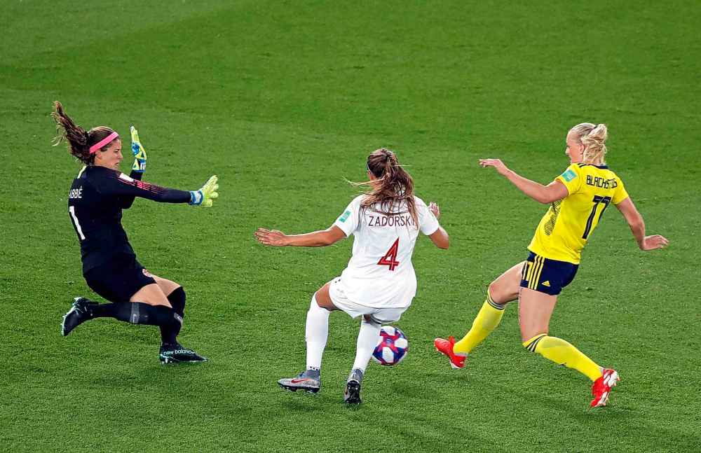 AP Photo/Michel Euler
Sweden's Stina Blackstenius, right, scores the opening goal past Canada goalkeeper Stephanie Labbe, left, and Shelina Zadorsky during the Women's World Cup round of 16 soccer match between Sweden and Canada at the Parc des Princes in Paris, France, Monday.
