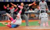 Home plate umpire Tony Randazzo, center, makes the call as Tampa Bay Rays pitcher Ryne Stanek, center, tumbles after trying to tag out New York Yankees' Luke Voit (45) in a collision at the plate during the eighth inning of a baseball game Sunday, May 12, 2019, in St. Petersburg, Fla. Voit scored on a wild pitch thrown by Stanek. (AP Photo/Steve Nesius)