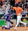 Houston Astros' Yuli Gurriel (10) points to the stands as he crosses home plate in front of Texas Rangers catcher Jeff Mathis on a home run during the second inning of a baseball game Friday, July 19, 2019, in Houston. (AP Photo/Michael Wyke)