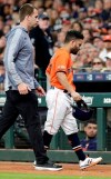 Houston Astros Jose Altuve, right, leaves the game with an injury after his single during the first inning of a baseball game against the Texas Rangers on Friday, May 10, 2019, in Houston. (AP Photo/Michael Wyke)
