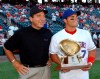 FILE - In this June 10, 2002, file photo, Cincinnati Reds Hall of Fame catcher Johhny Bench, left, and Texas Rangers catcher Ivan Rodriguez watch a short movie on the stadium scoreboard before the start of the Reds' game against the Rangers in Arlington, Texas. Rodriguez holds his 10th consecutive Golden Glove trophy presented to him by Bench. The stadium halfway between Dallas and Fort Worth, first known as The Ballpark in Arlington, is down to its final homestand after more than 2,000 regular season games over 26 seasons. (AP Photo/Tim Sharp, File)