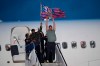 Washington Nationals manager Dave Martinez, left, waves a flag and Ryan Zimmerman, right, hoists the World Series trophy as the baseball team arrives at Dulles Airport, Thursday, Oct. 31, 2019, in Chantilly, Va. (AP Photo/Nick Wass)