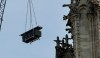 A crane hoists scaffolding past gargoyles outside the Notre Dame Cathedral in Paris, Thursday, April 18, 2019. Nearly $1 billion has already poured in from ordinary worshippers and high-powered magnates around the world to restore Notre Dame Cathedral in Paris after a massive fire. (AP Photo/Christophe Ena)