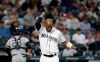 Seattle Mariners' Keon Broxton, foreground, knocks his helmet off after striking out looking as New York Yankees catcher Austin Romine, back left, heads to the dugout in the second inning of a baseball game Monday, Aug. 26, 2019, in Seattle. (AP Photo/Elaine Thompson)