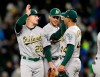 Oakland Athletics' Matt Chapman, left, Matt Olson, center, and Jesus Luzardo celebrate the 1-0 win over the Seattle Mariners in a baseball game, Saturday, Sept. 28, 2019, in Seattle. (AP Photo/John Froschauer)