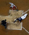 Milwaukee Brewers' Mike Moustakas slides safely past Cincinnati Reds catcher Tucker Barnhart during the fourth inning of a baseball game Wednesday, May 22, 2019, in Milwaukee. (AP Photo/Morry Gash)