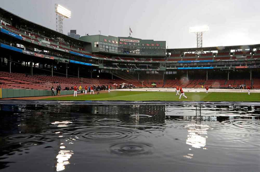 CP
The Boston Red Sox warm up next to a tarp-covered infield before Game 1 of the World Series against the Los Angeles Dodgers on Tuesday in Boston. (AP Photo/Matt Slocum)