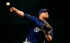 FILE - In this July 19, 2019 file photo, Milwaukee Brewers starting pitcher Jhoulys Chacin warms up during the first inning of a baseball game against the Arizona Diamondbacks, in Phoenix. Chacin helped buy plane tickets for a young Venezuelan team to compete in a tournament in Mexico, which they went on to win. It was a bright spot for a country more accustomed to news about political conflict and economic turmoil. (AP Photo/Ross D. Franklin, File)