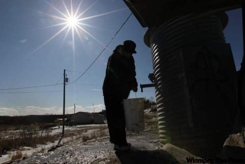 JOE.BRYKSA@FREEPRESS.MB.CA
Clyde Lonefoot, 19, gets a pail of treated water at one of the fresh-water delivery stations in St. Theresa Point First Nation.