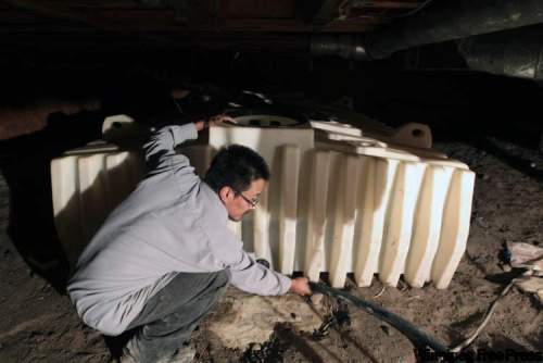 JOE.BRYKSA@FREEPRESS.MB.CA
Garden Hill’s Little family has a con­taminated cistern that made family members sick. Water treat­ment plant operator Bruce McDougall checks the storage tank in a crawl space under the home.