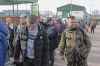 Polish volunteer Jedrzej, 34, in military uniform joins Ukranians, left, waiting to cross the border to go and fight against Russian forces, at Medyka border crossing, in Poland, Saturday, Feb. 26, 2022. (AP Photo/Visar Kryeziu)