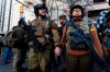 Demonstrators stand outside a security zone before a pro-gun rally, Monday, Jan. 20, 2020, in Richmond, Va. (AP Photo/Julio Cortez)