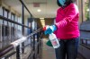 Deborah Boateng, a cleaner at Churchill High School, wipes down high-touch areas at the school in Winnipeg prior to the first day of classes. (Mikaela MacKenzie / Winnipeg Free Press files)