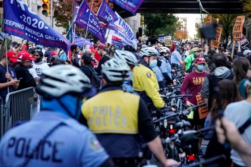 Police separate President Donald Trump supporters and pro-vote counting demonstrators outside the Philadelphia Convention Center three days after the presidential election polls closed as they await tabulation results, Friday, Nov. 6, 2020, in Philadelphia. The mission for Joe Biden, should he prove elected: bring the United States back together. THE CANADIAN PRESS/AP, John Minchillo