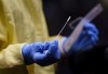 A nurse gets a swab ready to perform a test on a patient at a drive-in COVID-19 clinic in Montreal, on Wednesday, October 21, 2020. THE CANADIAN PRESS/Paul Chiasson