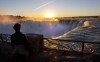 A man watches the sun rise over Niagara Falls in Niagara Falls, Ont. on Wednesday Nov. 4, 2020. Ottawa is rolling out a wave of new funding for pandemic-battered industries including tourism, the arts and regional aviation, with smaller companies top of mind — and large airlines notably absent. THE CANADIAN PRESS/Frank Gunn