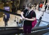 A health-care worker riding an escalator watches Ontario Premier Doug Ford speak to the media at a UHN COVID-19 vaccine clinic in Toronto on Thursday, Jan. 7, 2021. THE CANADIAN PRESS/Nathan Denette