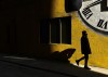 A man wearing a protective mask walks into the sunlight on a cold afternoon during the COVID-19 pandemic in Toronto on Thursday, February 11, 2021. THE CANADIAN PRESS/Nathan Denette