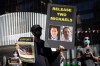 A person holds a sign with photographs of Michael Kovrig and Michael Spavor, who have been detained in China since December, 2018, as people gather for a rally in support of Hong Kong democracy, in Vancouver on August 16, 2020. THE CANADIAN PRESS/Darryl Dyck