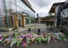 Flowers are seen at a makeshift memorial outside of the Lynn Valley Library in Lynn Valley in North Vancouver, B.C., Sunday, March 28, 2021. A 28-year-old man was charged Sunday with second-degree murder in a stabbing rampage that left a young woman dead and injured six others in and around a library in North Vancouver, B.C., a day earlier. THE CANADIAN PRESS/Jonathan Hayward