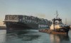 In this photo released by Suez Canal Authority, the Ever Given, a Panama-flagged cargo ship, is pulled by one of the Suez Canal tugboats, in the Suez Canal, Egypt, Monday, March 29, 2021. Engineers on Monday 