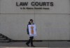 A supporter stands outside court in Edmonton on Thursday, March 4, 2021, as Pastor James Coates of GraceLife Church appears in court to appeal bail conditions. He was arrested for allegedly holding Sunday services in violation of COVID-19 rules. A trial is to begin Monday. THE CANADIAN PRESS/Jason Franson