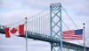 Canadian and American flags fly near the Ambassador Bridge at the Canada-USA border crossing in Windsor, Ont. on Saturday, March 21, 2020. THE CANADIAN PRESS/Rob Gurdebeke