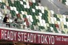 A TV cameraman sits beside empty spectators' seats during an athletics test event for Tokyo 2020 Olympics Games at the National Stadium, in Tokyo, Japan, Sunday, May 9, 2021. THE CANADIAN PRESS/AP/Shuji Kajiyama