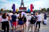 People watch on a giant screen the opening ceremony of the 2020 Summer Olympics in Tokyo, at the Trocadero gardens next to the Eiffel Tower in Paris, Friday, July 23, 2021. (AP Photo/Michel Euler)