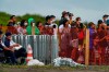 People watch from behind a security fence during the final day of the surfing competition at the 2020 Summer Olympics, Tuesday, July 27, 2021, at Tsurigasaki beach in Ichinomiya, Japan. The Olympic beach party that never was may be the only sore spot for surfing’s long-awaited debut that finished triumphantly this week. Some local Japanese fans and beachgoers did manage to find a way to lay eyes on the athletes and the competition site once the games began. (AP Photo/Francisco Seco)
