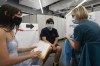 Anissa Barbato, left, discusses the Pfizer COVID-19 vaccine with Jolanta Gawlik before her son Samuel, center, is vaccinated, Friday, July 30, 2021 in New York. Amid increasing concern over the spread of the Delta variant, New York City announced on Wednesday that anyone can receive $100 if they get the first dose of the COVID-19 vaccine at any city-run vaccination clinic. (AP Photo/Mark Lennihan)