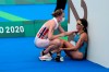 FILE - In this July 27, 2021, file photo, Claire Michel of Belgium is assisted by Lotte Miller of Norway after the finish of the women's individual triathlon competition at the 2020 Summer Olympics, in Tokyo, Japan. In an extraordinary Olympic Games where mental health has been front and center, acts of kindness are everywhere. The world’s most competitive athletes have been captured showing gentleness and warmth to one another — celebrating, pep-talking, wiping away each another’s tears of disappointment. (AP Photo/David Goldman, File)