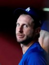 Los Angeles Dodgers' Max Scherzer talks to players in the dugout before the team's baseball game against the Arizona Diamondbacks, Saturday, July 31, 2021, in Phoenix. (AP Photo/Rick Scuteri)