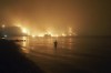 FILE - In this file photo dated Friday, Aug. 6, 2021, a man watches as wildfires approach Kochyli beach near Limni village on the island of Evia, about 160 kilometers (100 miles) north of Athens, Greece. A new massive United Nations science report is scheduled for release Monday Aug. 9, 2021, reporting on the impact of global warming due to humans. (AP Photo/Thodoris Nikolaou)