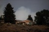 Smoke from the Tremont Creek wildfire burning on a mountain rises in the distance behind a home in Ashcroft, B.C., on Thursday, July 15, 2021. British Columbia's wildfire danger map shows a low to moderate fire risk over much of the province after a rainy weekend, but the extreme risk is expected to resume quickly as another hot spell arrives. THE CANADIAN PRESS/Darryl Dyck