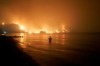 In this file photo dated Friday, Aug. 6, 2021, a man watches as wildfires approach Kochyli beach near Limni village on the island of Evia, about 160 kilometers (100 miles) north of Athens, Greece. A new massive United Nations science report is scheduled for release Monday Aug. 9, 2021, reporting on the impact of global warming due to humans. THE CANADIAN PRESS/AP/Thodoris Nikolaou