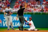 Philadelphia Phillies' Jean Segura, right, reacts after being called out by Alfonso Marquez, center, while trying to steal second during the first inning of a baseball game against the Los Angeles Dodgers, Tuesday, Aug. 10, 2021, in Philadelphia. (AP Photo/Matt Slocum)