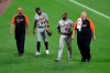 Detroit Tigers' Derek Hill, center left, and Akil Baddoo walk off the field, escorted by trainers, after they collided while chasing a long fly ball hit by Baltimore Orioles' Anthony Santander during the eighth inning of a baseball game, Tuesday, Aug. 10, 2021, in Baltimore.(AP Photo/Gail Burton)