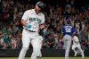 Seattle Mariners' Luis Torrens, left, celebrates his single that scored Jarred Kelenic with the winning run off of Texas Rangers pitcher Dennis Santana (56) during the ninth inning of a baseball game Wednesday, Aug. 11, 2021, in Seattle. The Mariners won 2-1. (AP Photo/Ted S. Warren)