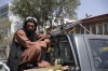 A Taliban fighter sits on the back of vehicle with a machine gun in front of the main gate leading to the Afghan presidential palace, in Kabul, Afghanistan, Monday, Aug. 16, 2021. The U.S. military has taken over Afghanistan's airspace as it struggles to manage a chaotic evacuation after the Taliban rolled into the capital. (AP Photo/Rahmat Gul)