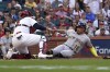 Milwaukee Brewers' Kolten Wong (16) is tagged out at home by St. Louis Cardinals catcher Yadier Molina during the first inning of a baseball game Tuesday, Aug. 17, 2021, in St. Louis. (AP Photo/Jeff Roberson)