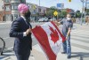 NDP Leader Jagmeet Singh stretches out a supporter's Canadian flag for a photo during a campaign stop in Toronto, on Monday, August 16, 2021. THE CANADIAN PRESS/Paul Chiasson