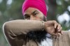 New Democratic leader Jagmeet Singh coughs into his elbow as he stands at the microphone during a campaign stop, Tuesday, Aug. 31, 2021 in Coquitlam, B.C. THE CANADIAN PRESS/Adrian Wyld