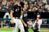 Chicago White Sox head trainer James Kruk, center, walks with starting pitcher Lucas Giolito to the clubhouse as catcher Yasmani Grandal, right, heads to the mound during the fifth inning of a baseball game against the Pittsburgh Pirates Tuesday, Aug. 31, 2021, in Chicago. (AP Photo/Charles Rex Arbogast)