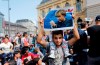 In this Sept. 4, 2015 file photo a migrant holds up a poster of German Chancellor Angela Merkel before starting a march out of Budapest, Hungary, towards Austria. In 2015, Merkel was the face of a welcoming approach to migrants as people fleeing conflicts in Syria and elsewhere trekked across the Balkans, allowing in hundreds of thousands and insisting that 